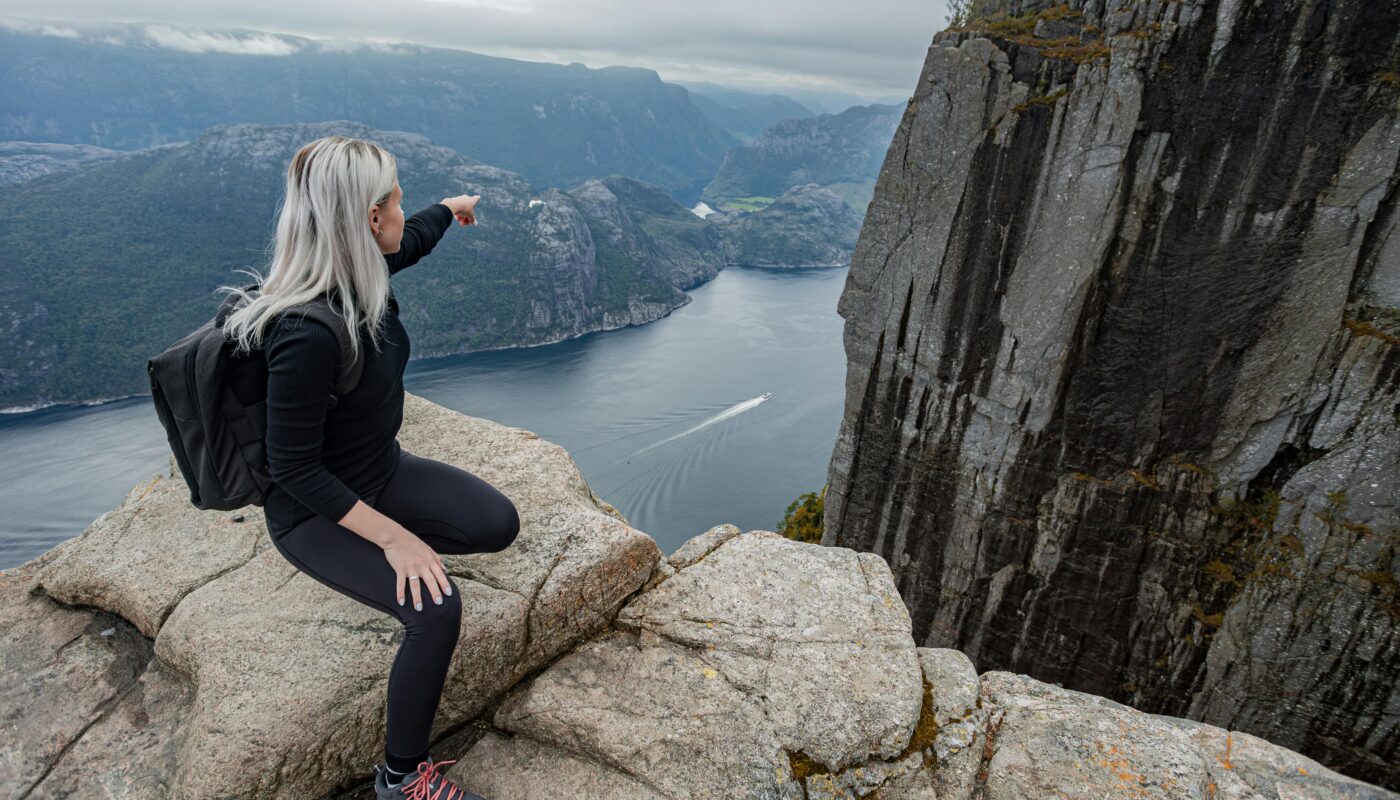 https://www.pexels.com/photo/a-girl-with-a-backpack-sitting-on-the-edge-of-the-cliff-in-the-mountains-on-a-hike-in-norway-on-fjord-18307643/