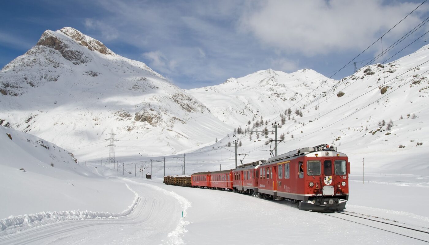 https://www.pexels.com/photo/red-and-black-train-running-along-snow-covered-field-78791/